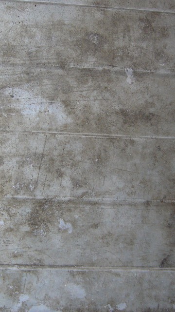 Image person in black shoes standing on gray concrete floor