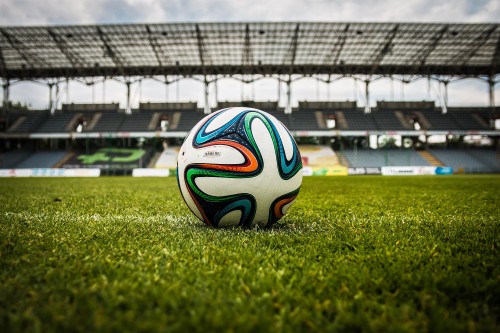 Image white blue and black soccer ball on green grass field during daytime