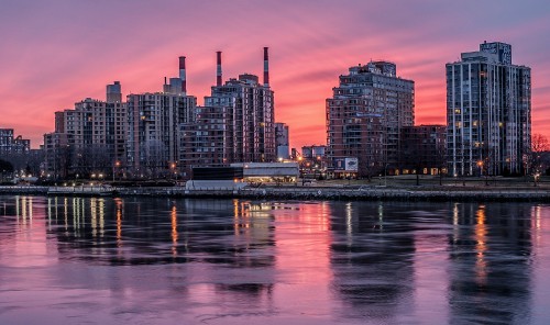 Image city skyline across body of water during night time