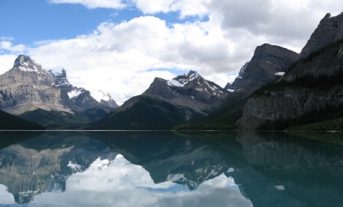 Image lake near mountain under white clouds during daytime