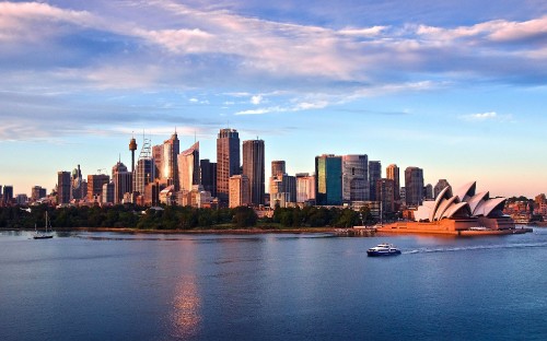 Image city skyline across body of water under cloudy sky during daytime