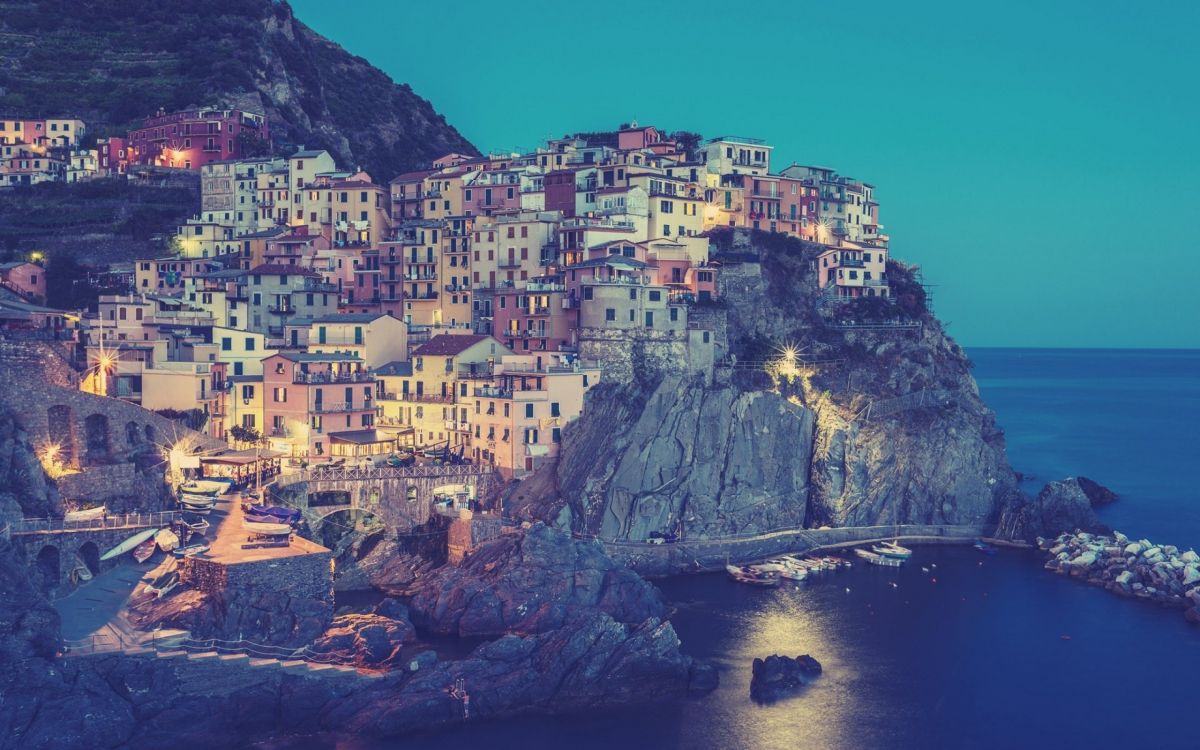 houses on cliff near body of water during daytime