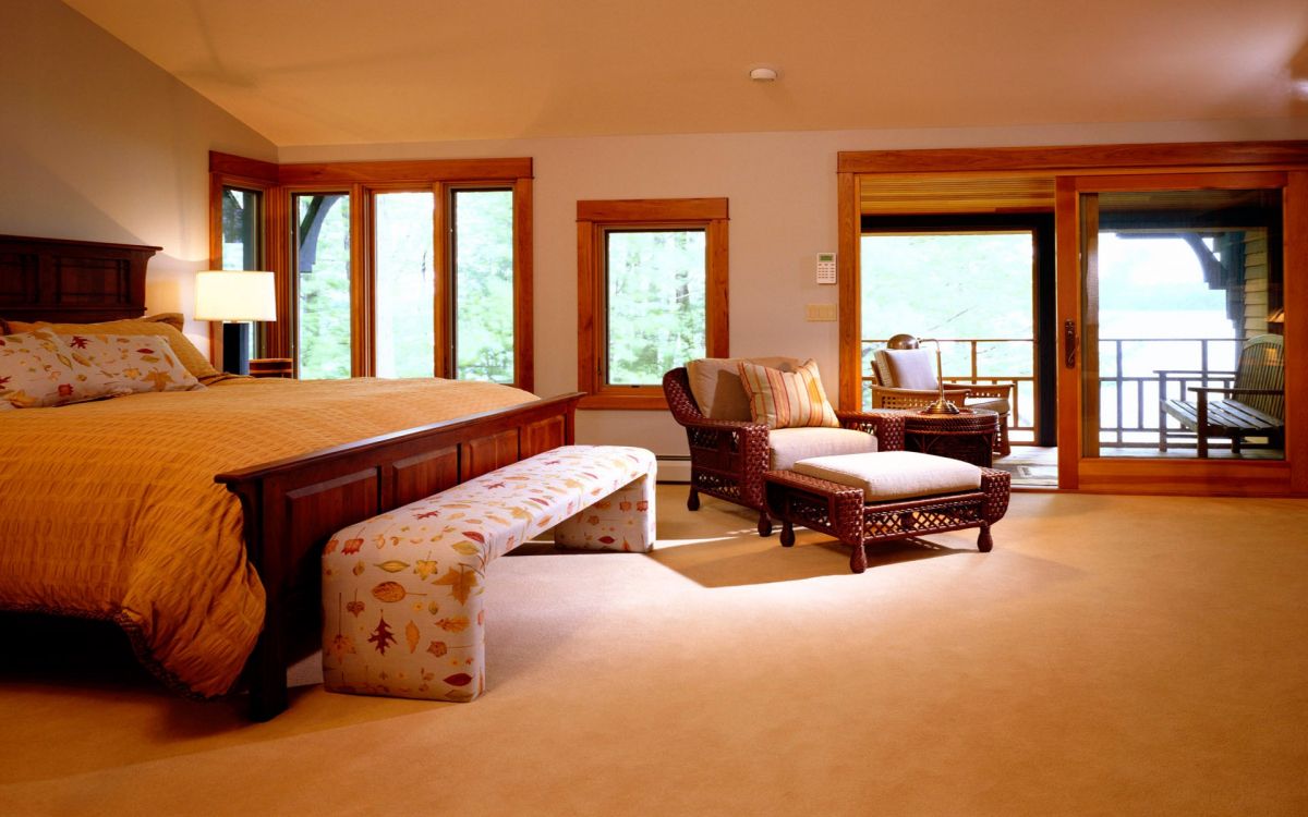 white and brown floral sofa near brown wooden framed glass window