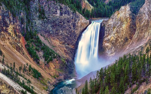 Image waterfalls between green and brown mountains during daytime