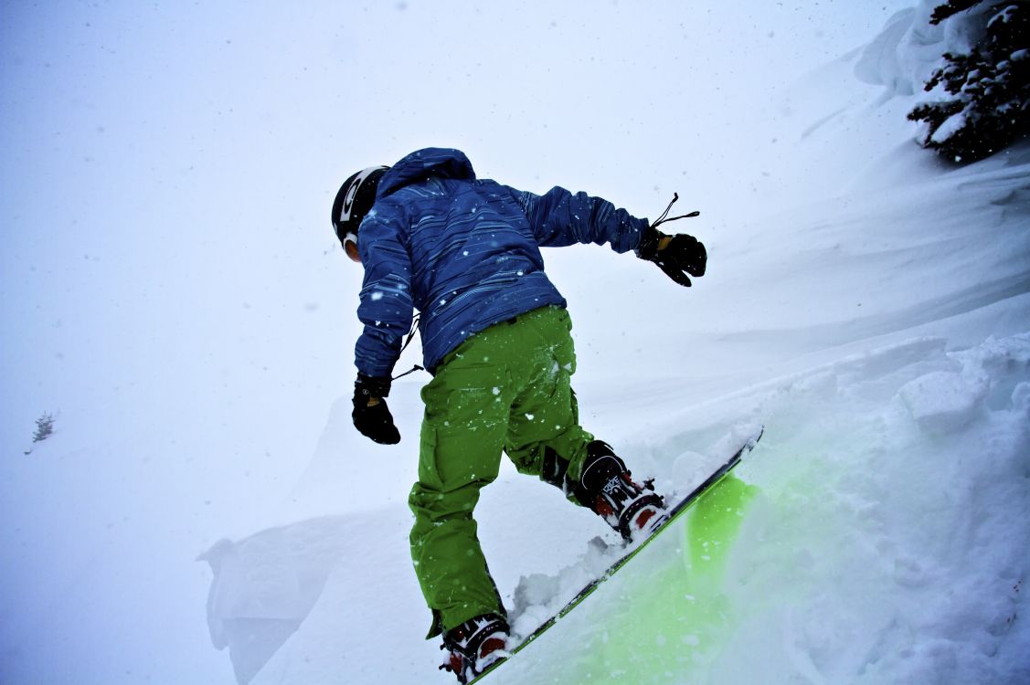 Persona Con Chaqueta Azul y Pantalones Verdes Montados Sobre Palas de Esquí Sobre un Terreno Cubierto. Wallpaper in 5184x3448 Resolution