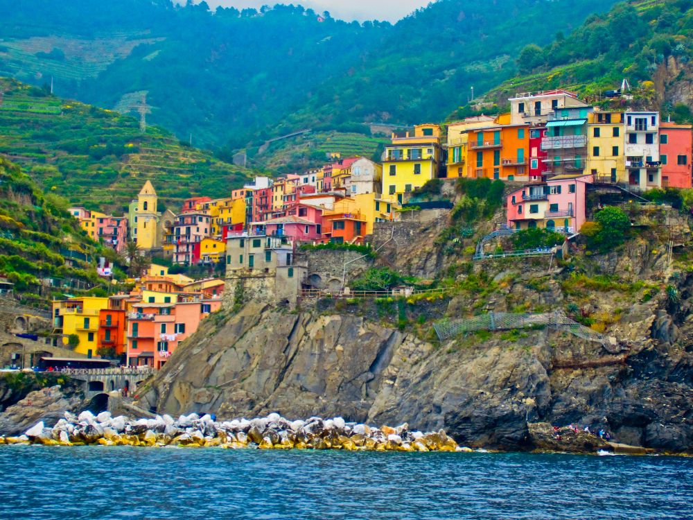 houses on mountain near body of water during daytime