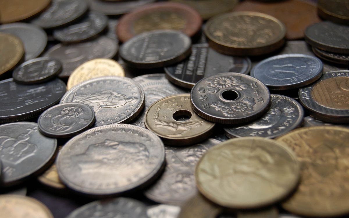 silver round coins on black surface