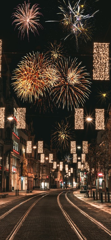 Image people walking on street with fireworks display during night time