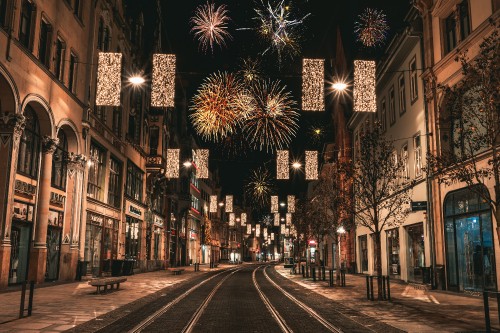 Image people walking on street with fireworks display during night time