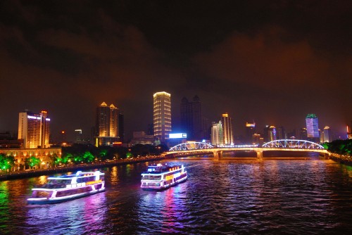 Image white and blue boat on water near city buildings during night time