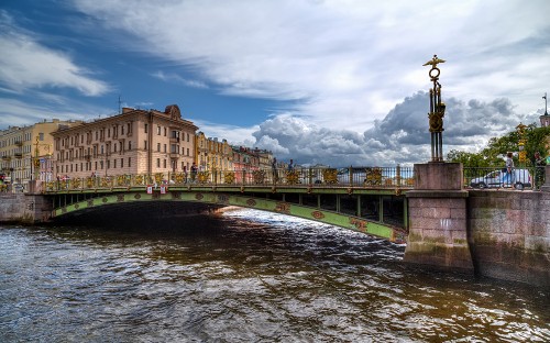 Image brown concrete building near bridge under cloudy sky during daytime