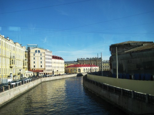 Image white and brown concrete building beside river under blue sky during daytime