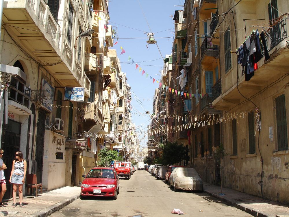 Voiture Rouge Garée à Côté du Bâtiment en Béton Gris Pendant la Journée. Wallpaper in 3072x2304 Resolution