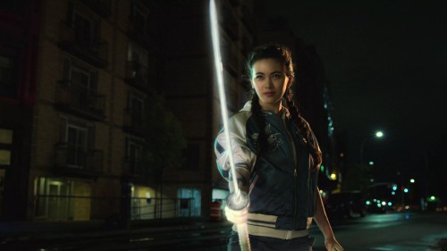 Image woman in black jacket standing on sidewalk during night time