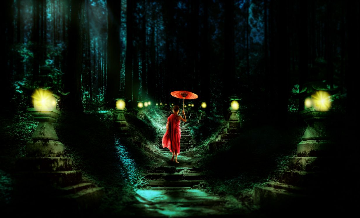 woman in red dress holding umbrella walking on pathway