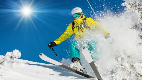 Image person in yellow jacket and red helmet riding on white and red snowboard during daytime