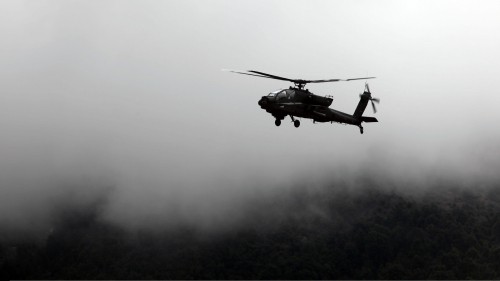 Image black helicopter flying over the clouds