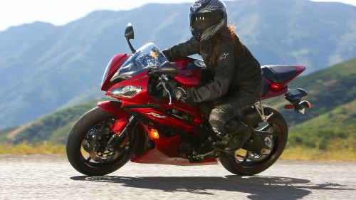 Image man in black jacket riding red sports bike