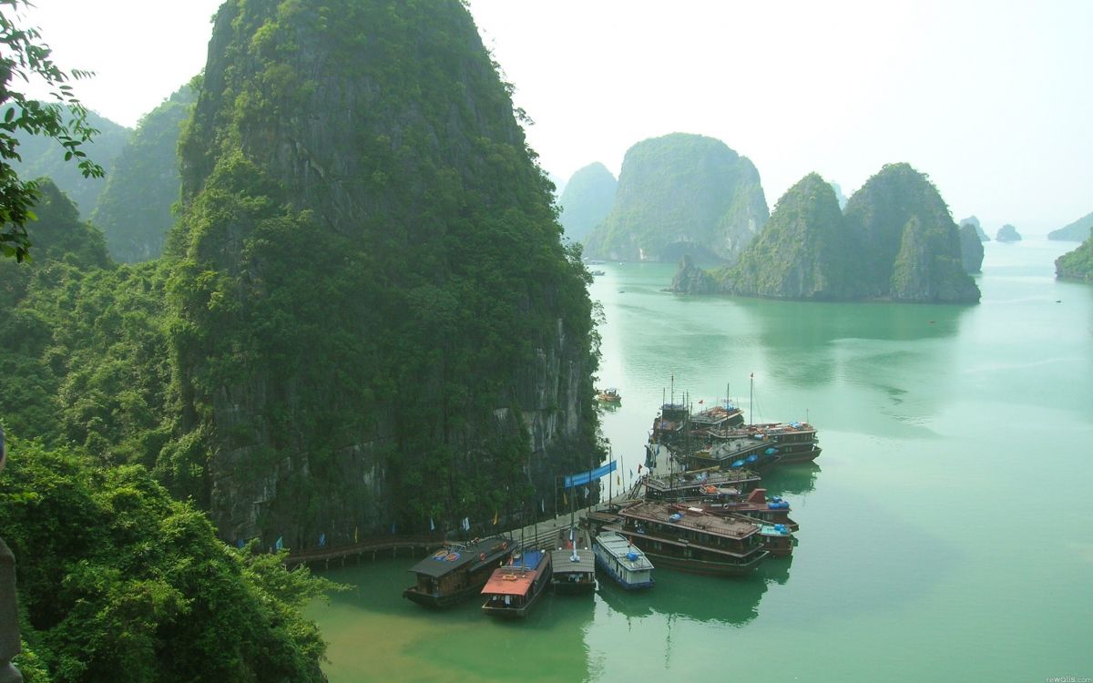 boats on water near mountain during daytime