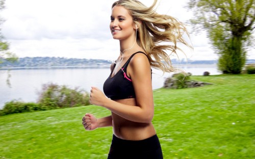 Image woman in black tank top and black shorts standing on green grass field during daytime