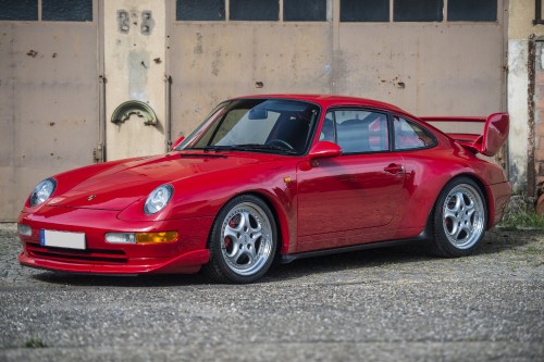 Image red porsche 911 parked on grey concrete pavement