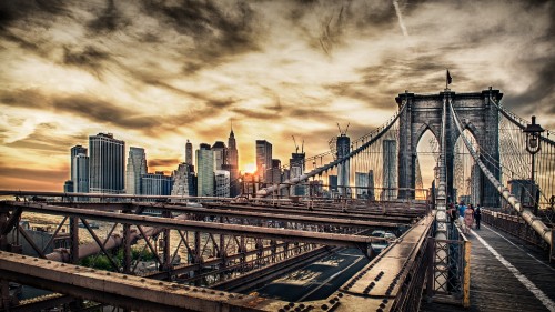 Image bridge over body of water near city buildings during daytime