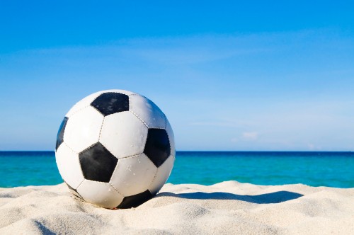 Image white and black soccer ball on white sand during daytime