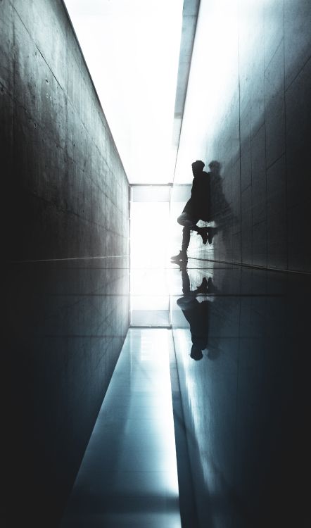 Mann in Schwarzer Jacke Geht Auf Flur. Wallpaper in 3215x5448 Resolution