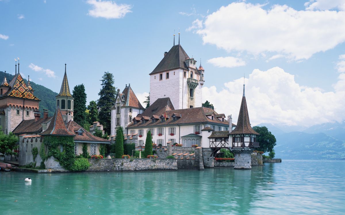 Weißes Und Braunes Betongebäude Neben Dem Gewässer Tagsüber. Wallpaper in 2560x1600 Resolution