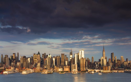 Image city skyline across body of water during daytime