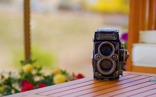 Image black and silver camera on brown wooden table