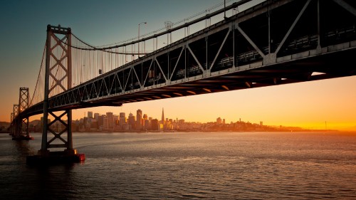 Image black bridge over body of water during sunset