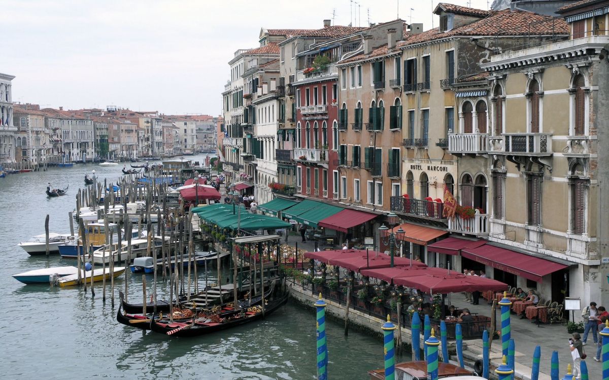 people walking on wooden dock near buildings during daytime