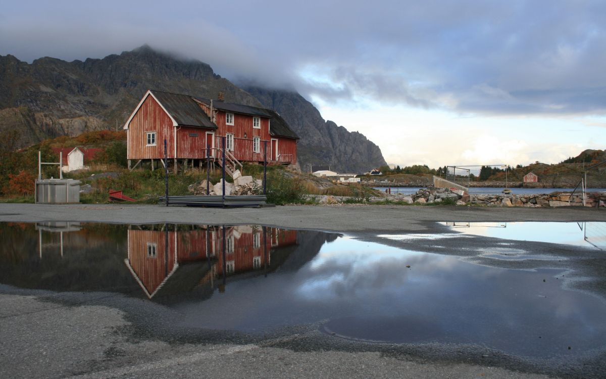 brown wooden house near body of water during daytime