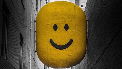 Image yellow smiley balloon on gray wooden plank