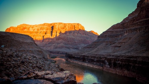 Image brown rocky mountain beside body of water during daytime