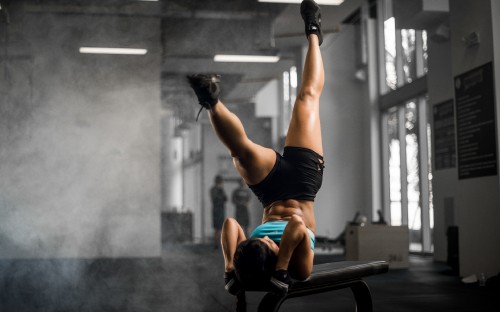 Image woman in red sports bra and black shorts doing exercise