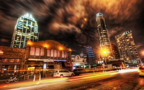 Image cars on road near high rise buildings during night time