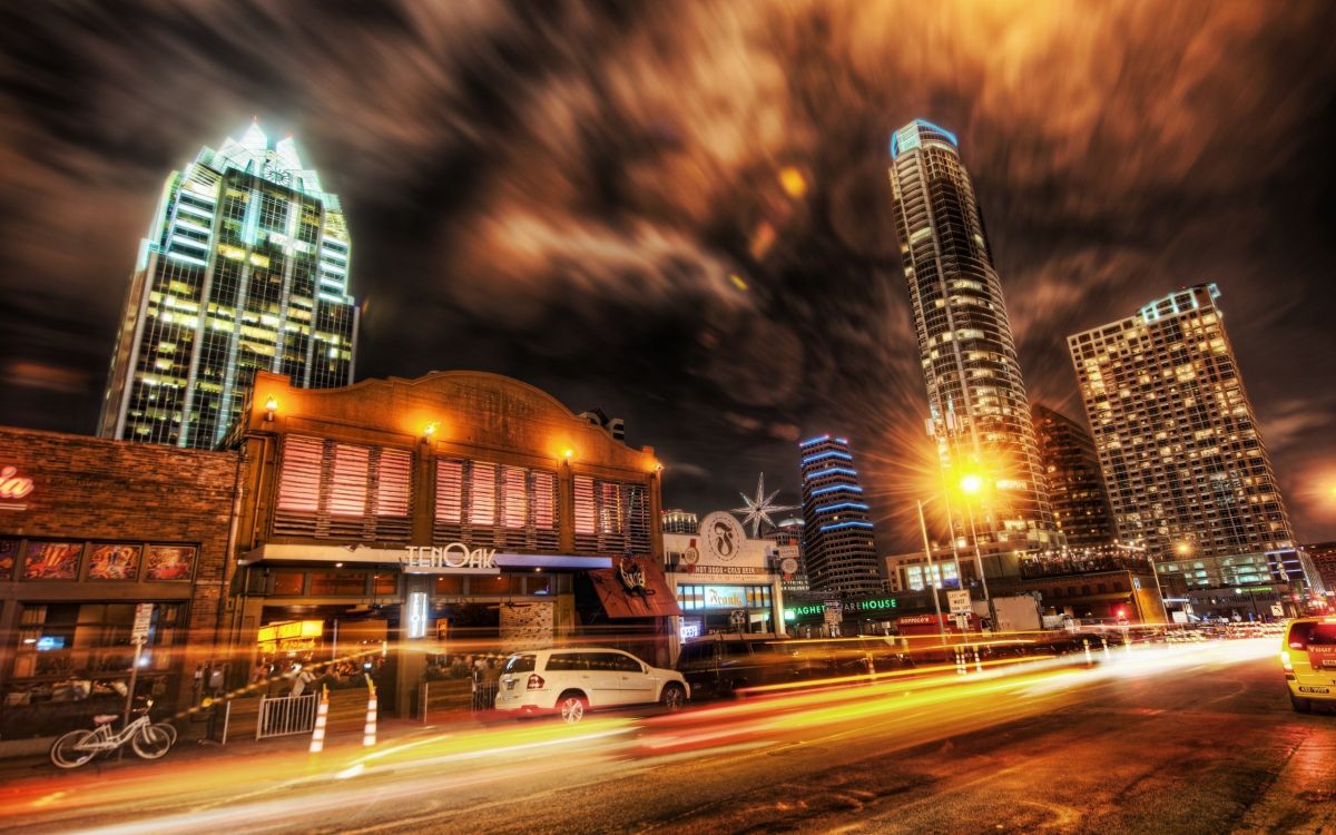 cars on road near high rise buildings during night time