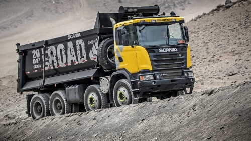 Image black and yellow truck on gray sand during daytime