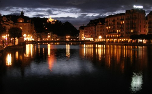 Image brown concrete building near body of water during night time