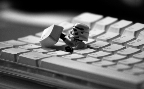 Image white and black lego mini figure on white computer keyboard