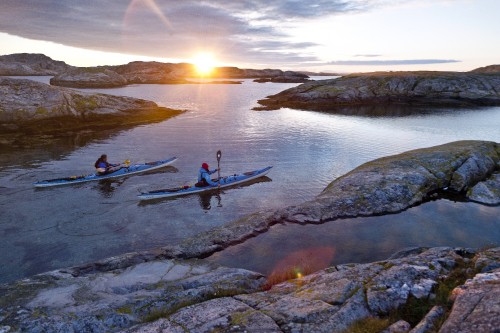 Image 2 men riding on boat during sunset
