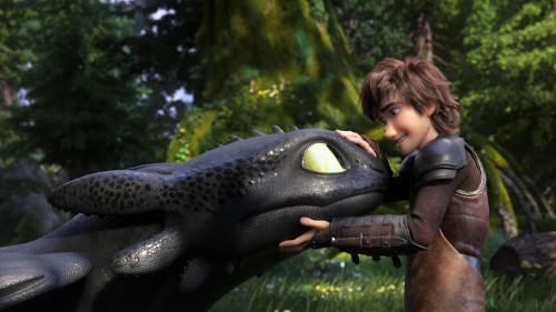 Image boy in black jacket standing beside black crocodile statue