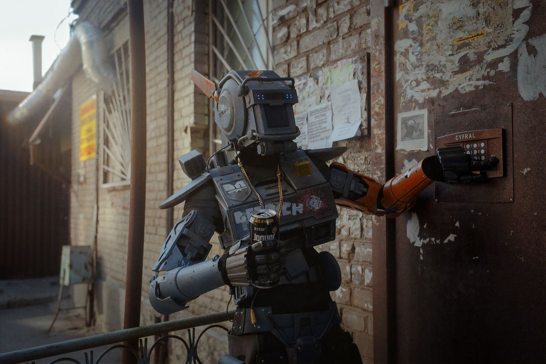 gray robot holding black and orange gun