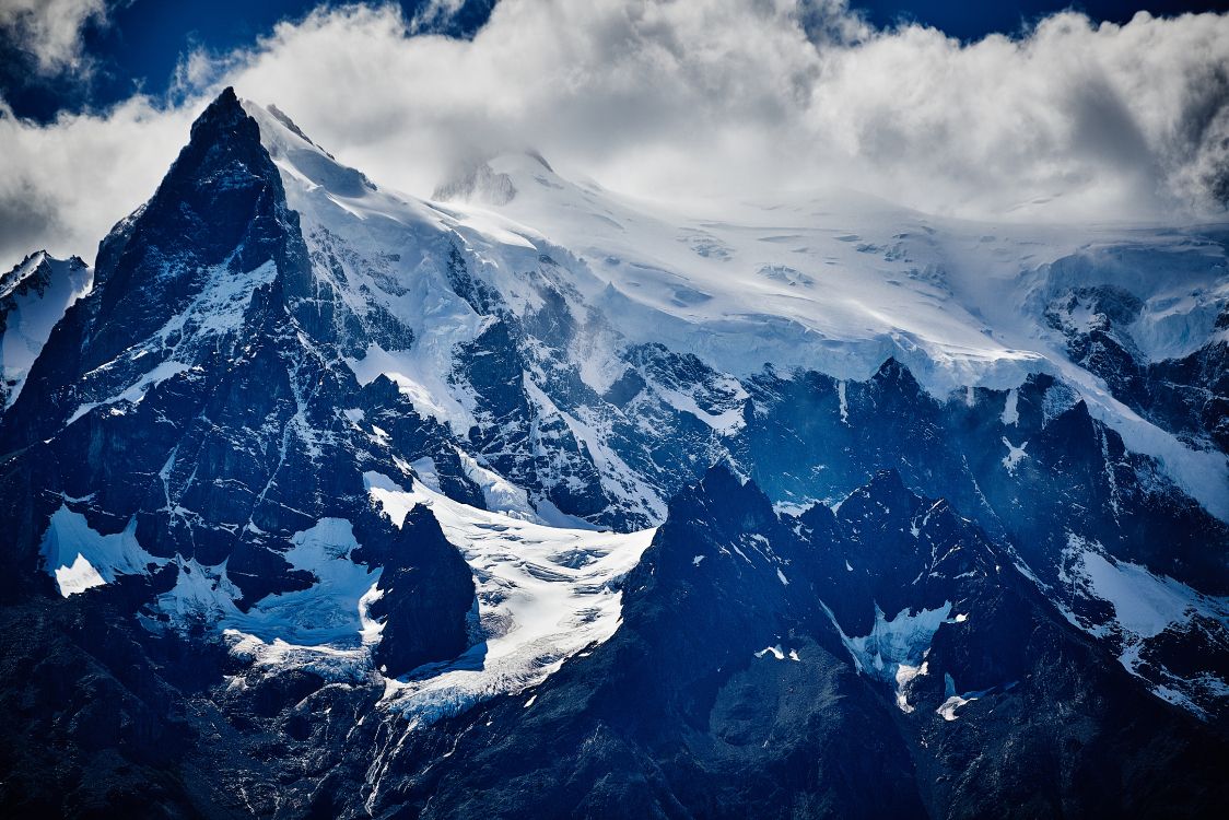 snow covered mountain under cloudy sky during daytime