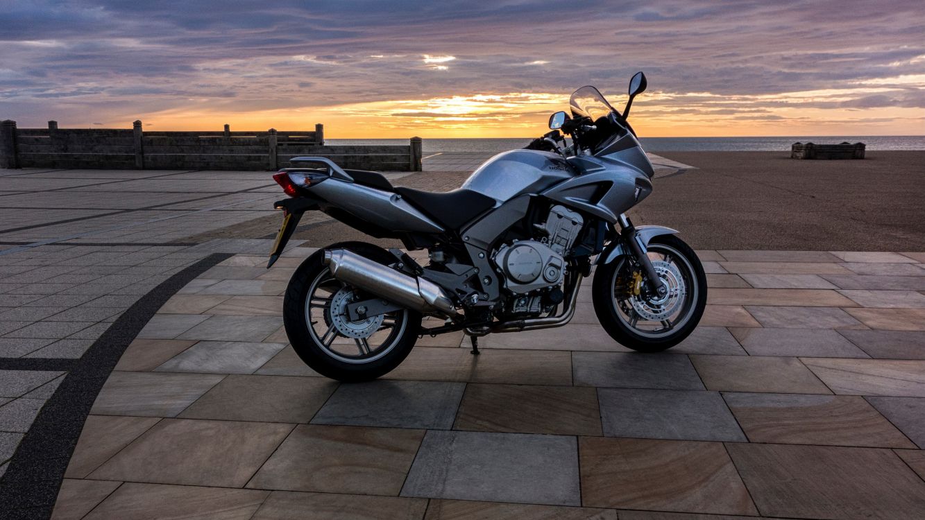 black and silver cruiser motorcycle on gray concrete floor during sunset