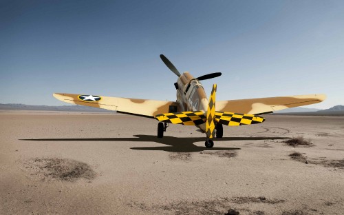 Image yellow and white plane on gray sand during daytime