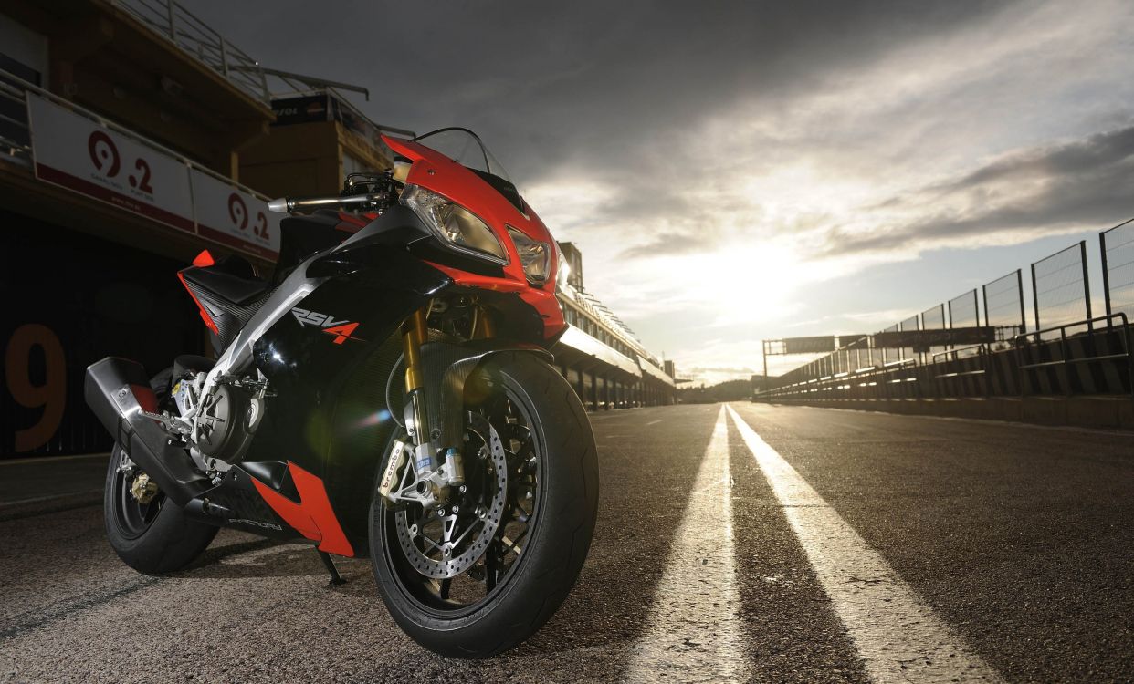 red and black sports bike parked on gray concrete floor during daytime