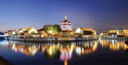 Image brown and white temple near body of water during night time